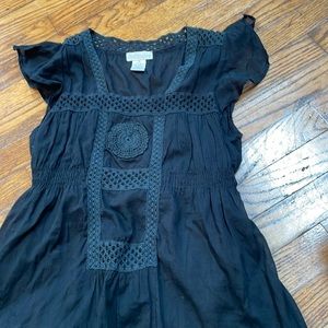 Woman’s black top with embroidered trim.